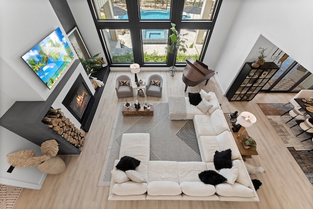 living room with wood-type flooring and a towering ceiling