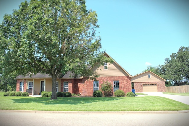 view of front of home featuring a front yard, fence, driveway, a garage, and brick siding