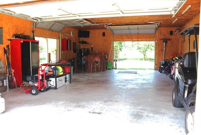 garage featuring electric panel and wooden walls