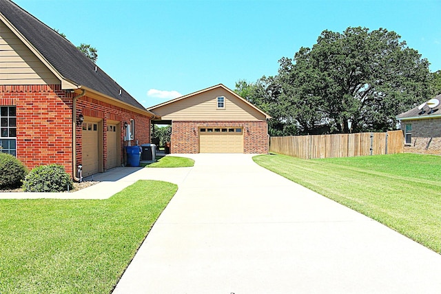 exterior space featuring driveway, brick siding, a lawn, and fence