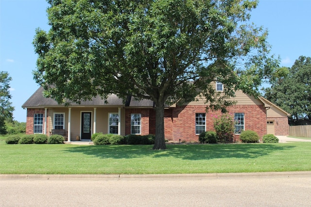 view of front of home featuring brick siding, an attached garage, and a front yard