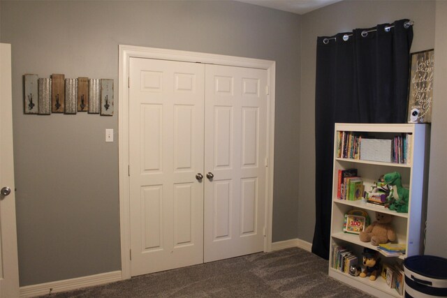 interior space with dark carpet and a closet