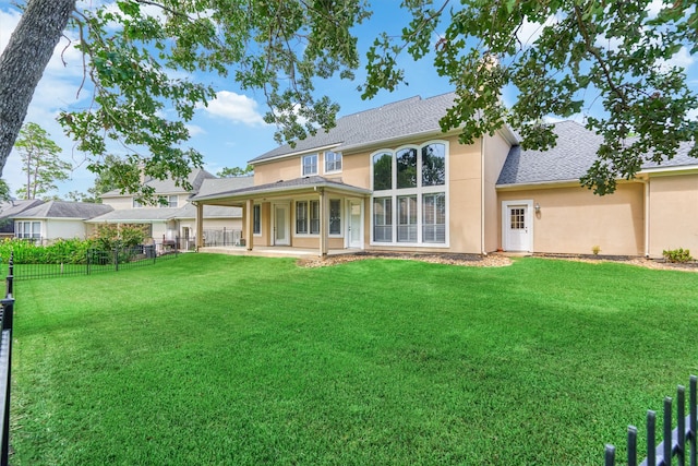 rear view of property with a patio and a yard