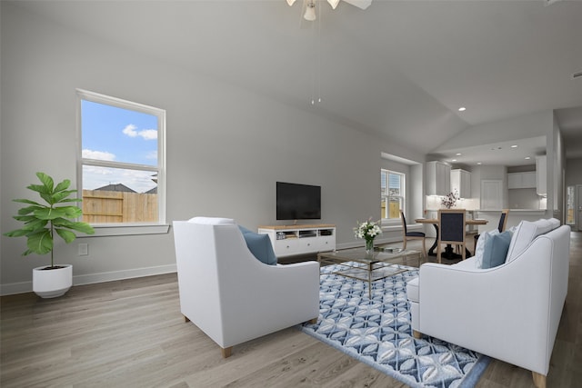 living room with light hardwood / wood-style flooring, lofted ceiling, and ceiling fan