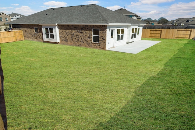 back of house with a lawn and a patio