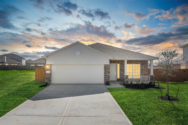 single story home featuring a lawn and a garage