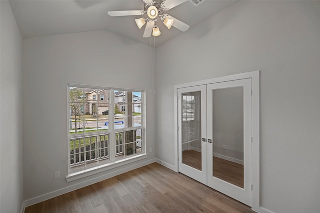 spare room with high vaulted ceiling, ceiling fan, french doors, and light hardwood / wood-style floors