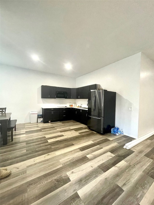 kitchen with light hardwood / wood-style flooring and stainless steel refrigerator