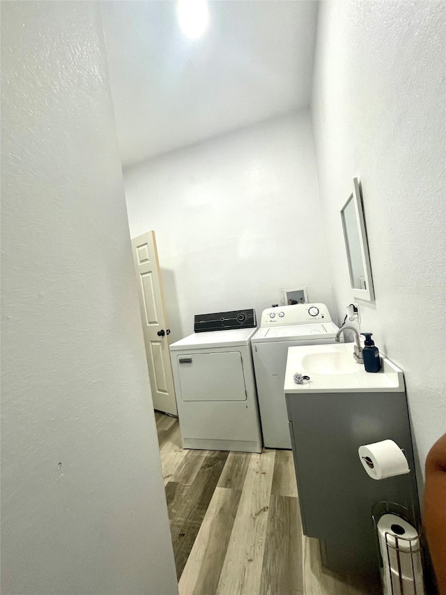 interior space with washing machine and dryer and light hardwood / wood-style floors