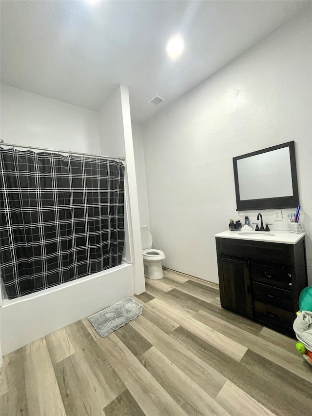 full bathroom with shower / bath combo, toilet, hardwood / wood-style flooring, and vanity