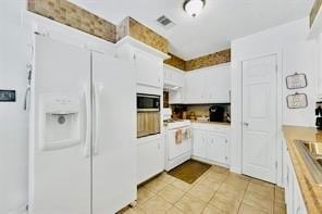 kitchen with white cabinets, butcher block counters, and white appliances