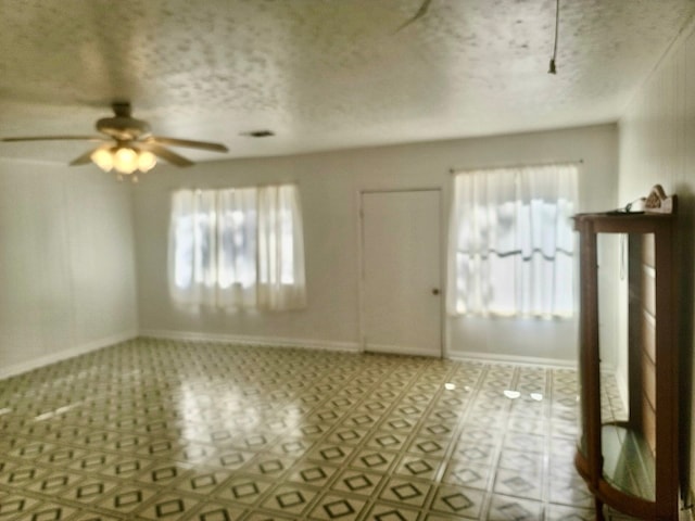 entryway featuring a textured ceiling, ceiling fan, and a wealth of natural light