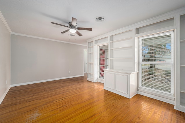 empty room with a textured ceiling, ceiling fan, light hardwood / wood-style floors, and crown molding