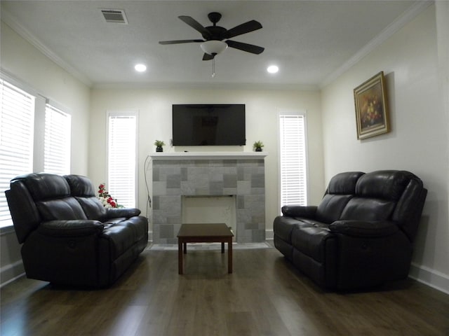 living area featuring ornamental molding, visible vents, baseboards, and wood finished floors