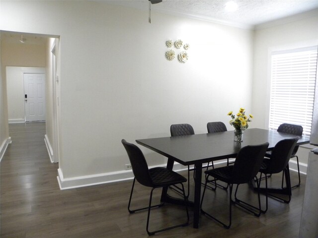 dining space with dark wood-type flooring, a textured ceiling, crown molding, and a wealth of natural light