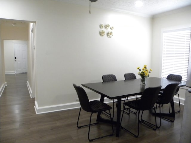 dining room featuring a textured ceiling, dark wood-type flooring, baseboards, and crown molding