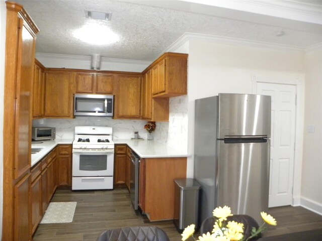 kitchen with tasteful backsplash, dark hardwood / wood-style flooring, stainless steel appliances, and a textured ceiling