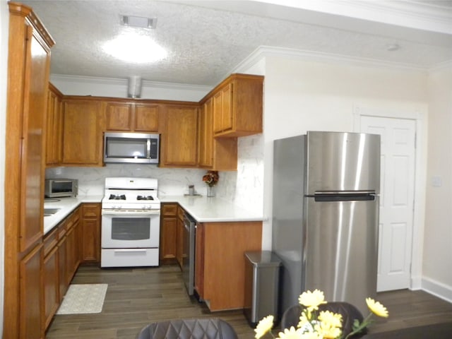 kitchen featuring crown molding, stainless steel appliances, visible vents, decorative backsplash, and dark wood-type flooring