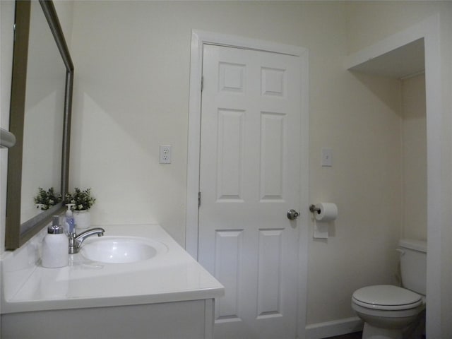 half bath featuring vanity and toilet