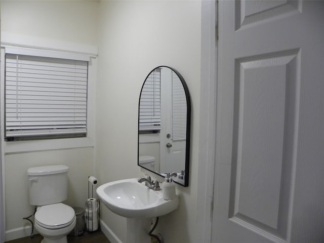 bathroom with toilet, baseboards, and a sink