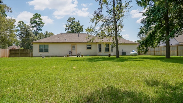 back of property with cooling unit and a lawn