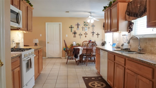 kitchen featuring ceiling fan, light tile patterned floors, sink, white appliances, and backsplash