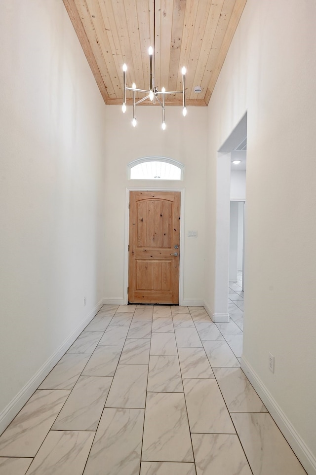 tiled entrance foyer featuring wooden ceiling and an inviting chandelier