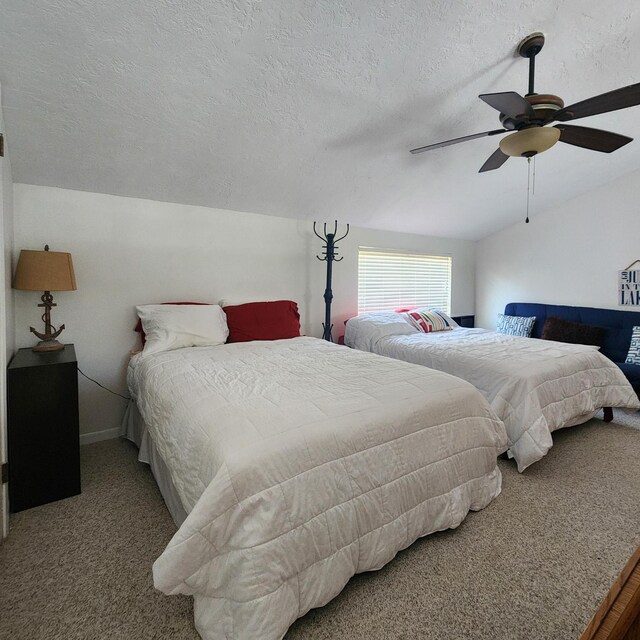 bedroom featuring carpet flooring, ceiling fan, lofted ceiling, and a textured ceiling