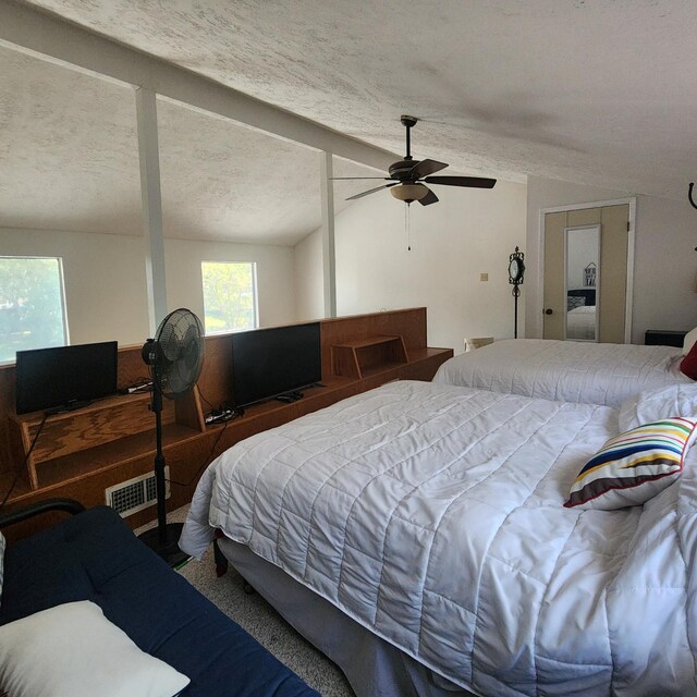 carpeted bedroom with a textured ceiling, ceiling fan, and lofted ceiling