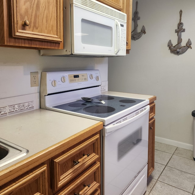 kitchen with light tile patterned floors and white appliances