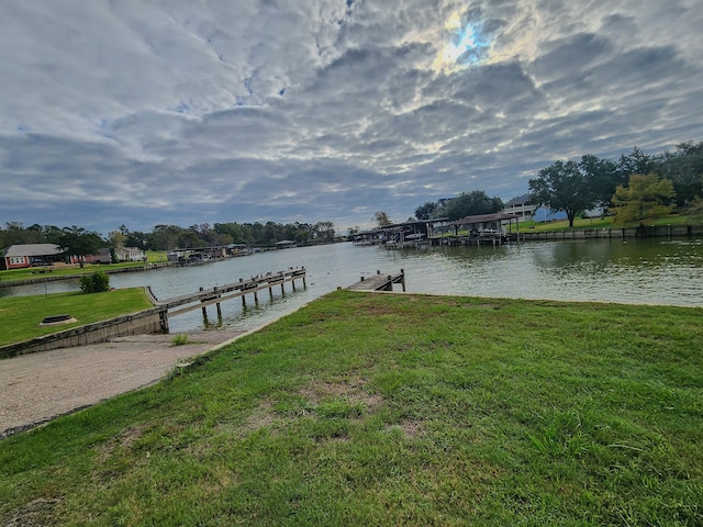 view of dock featuring a yard and a water view