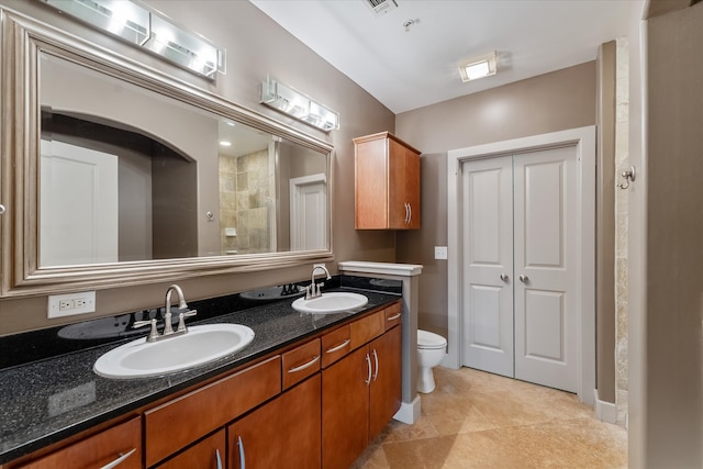 bathroom with dual bowl vanity, walk in shower, tile patterned floors, and toilet