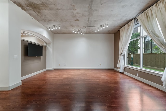 empty room with rail lighting and hardwood / wood-style flooring