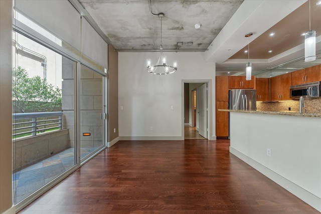 interior space featuring sink, dark wood-type flooring, an inviting chandelier, and a raised ceiling