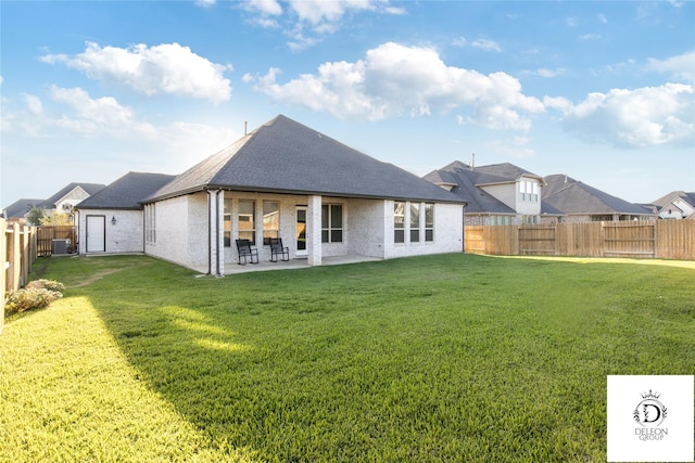 back of house featuring a lawn and a patio