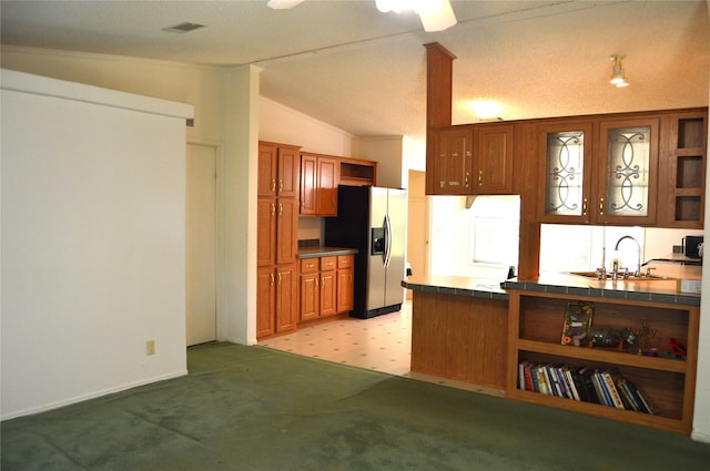 kitchen with stainless steel fridge with ice dispenser, lofted ceiling, ceiling fan, light tile patterned floors, and sink