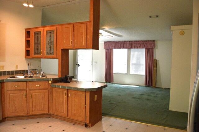 kitchen featuring light tile patterned floors, sink, ceiling fan, and tile countertops