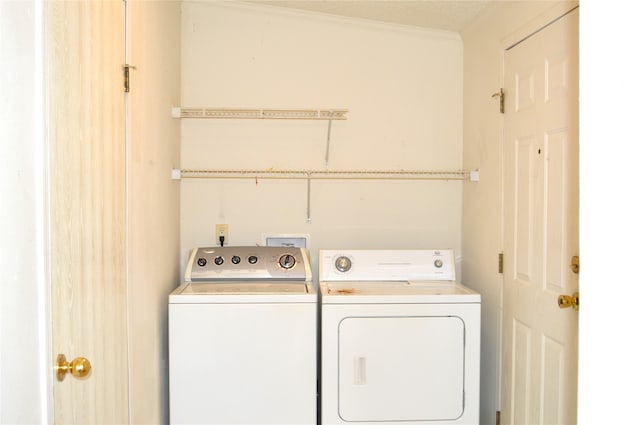 laundry area with ornamental molding and washer and dryer