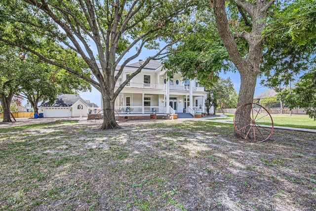 view of front of house featuring a balcony and a front yard