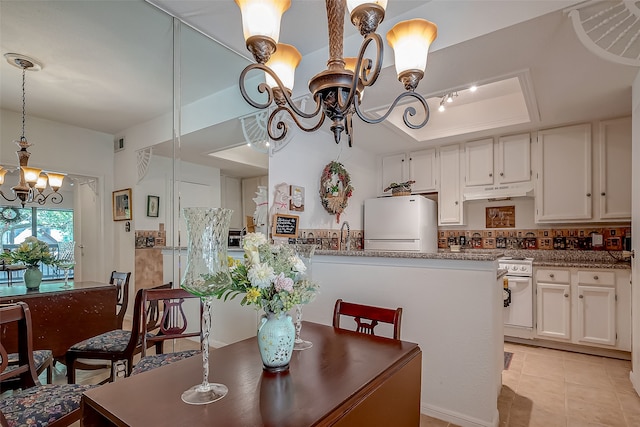 tiled dining room featuring sink and a notable chandelier