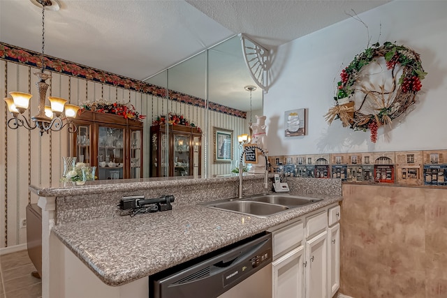 kitchen featuring hanging light fixtures, white cabinetry, dishwasher, a notable chandelier, and sink