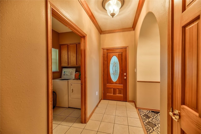 foyer with light tile patterned flooring, separate washer and dryer, and crown molding