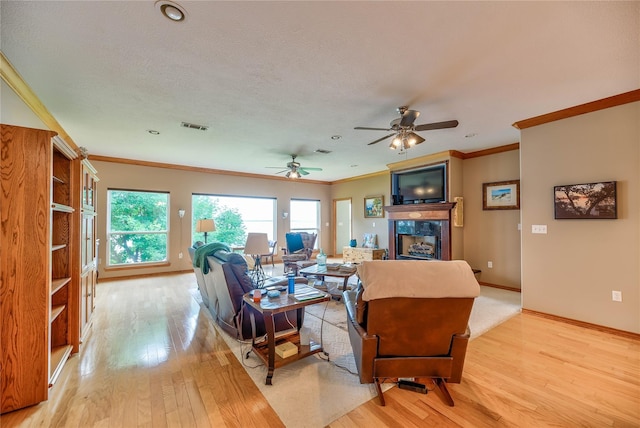 living room featuring crown molding, ceiling fan, and light hardwood / wood-style flooring