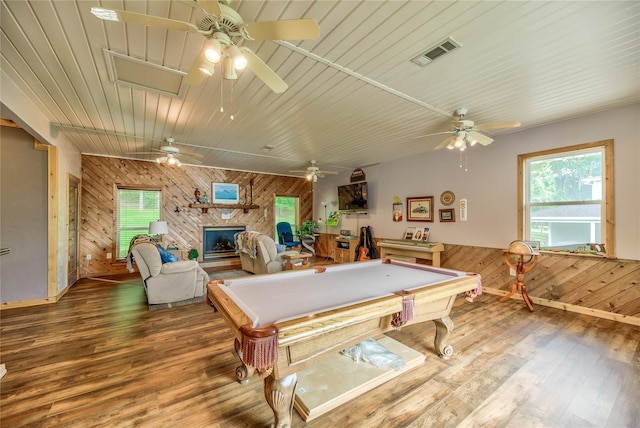 rec room featuring hardwood / wood-style flooring, a fireplace, wooden walls, and billiards