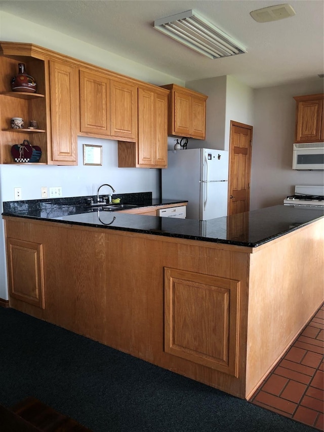 kitchen featuring sink, dark stone counters, white appliances, and kitchen peninsula