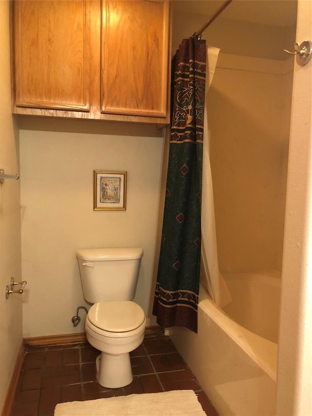 bathroom featuring tile patterned flooring, shower / tub combo, and toilet