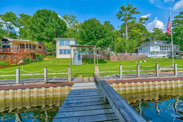 dock area with a water view and a yard