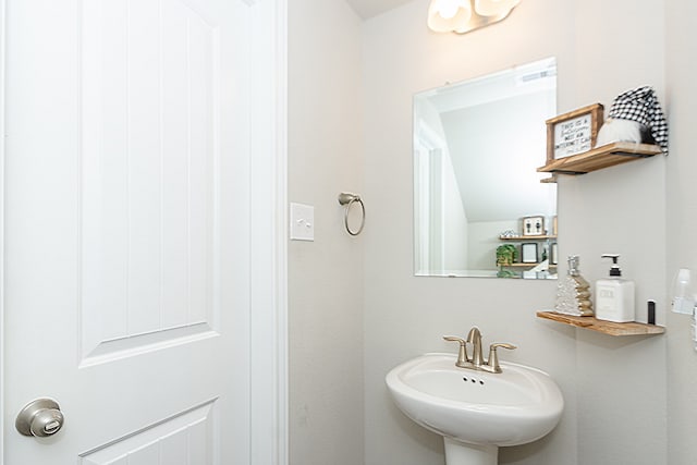 bathroom with sink and lofted ceiling