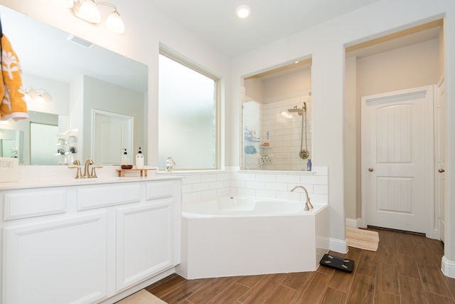 bathroom with vanity and shower with separate bathtub