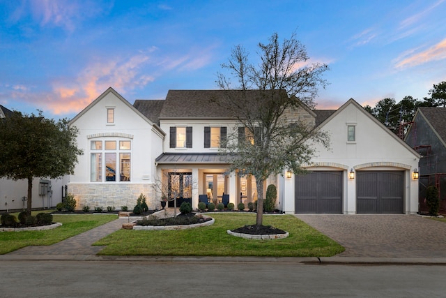 view of front of house with a garage and a yard